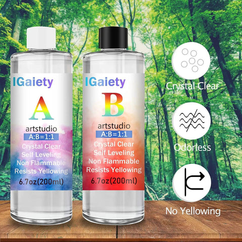 Backdrop of forest with two epoxy bottles labeled A and B featuring clear, odorless, non-yellowing liquids, part of Backward Alphabet Molds Starter Kit With 206 Silicone Resin Molds For Epoxy Jewelry Making And Keychains Beginner Friendly Craft Set Includes Accessories For Easy Casting And DIY Projects.