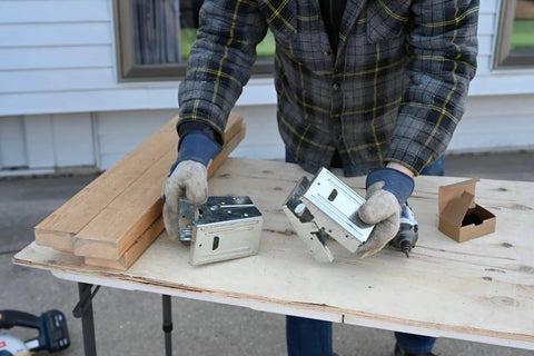 Person assembling Galvanized 2x4 Sawhorse Brackets Set Of 4 for durable sawhorses with lumber on outdoor workbench
