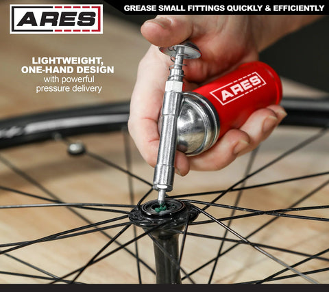 Red ARES 3-ounce push-type mini grease gun with needle nozzle used on bicycle wheel hub
