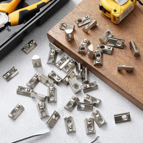 100 Pcs M5 Spring T Nuts For Aluminum Extrusion European Standard scattered on a workbench with tools.