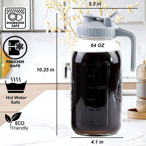 64 oz glass pitcher with handle, lid, and measurement markings, shown on kitchen counter. Dishwasher, freezer, hot water safe features visible.