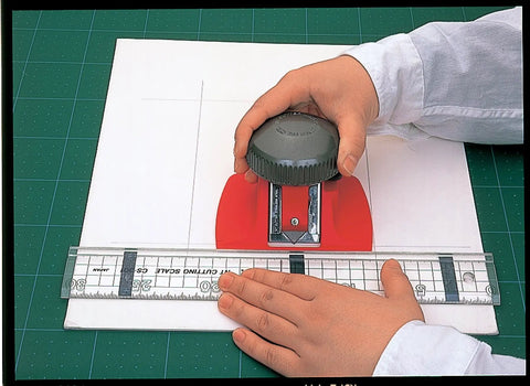 Hand using Mat Board Cutter 45 Degree Bevel For Precise Framing Aluminum Die Cast Grip NT Professional MAT45P with ruler on mat board
