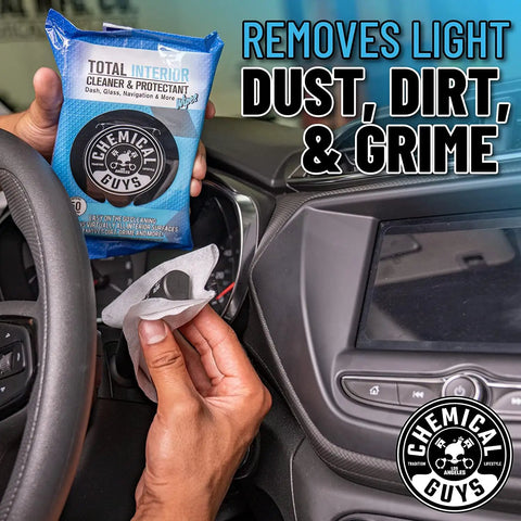 Hand holding Total Interior Cleaner And Protectant Wipes Mega 50 Pack For Cars Trucks SUVs Motorcycles RVs And More Safe Easy Clean Up No Mess For All Surfaces By Chemical Guys in car interior.