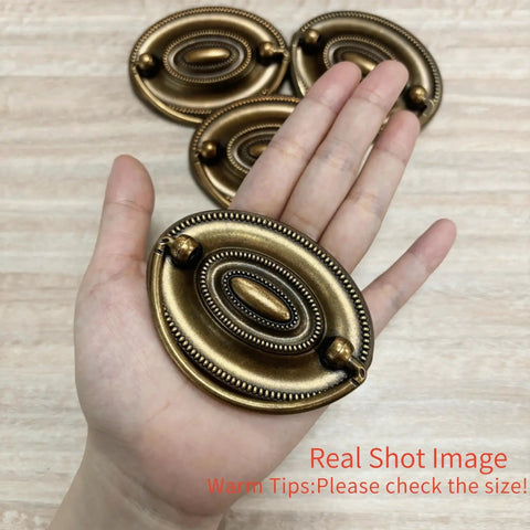 Person holding 4 Pcs Antique Brass Bail Drawer Pulls Oval Drop Swing Handles For Dresser And Cabinet, Zinc Alloy Hardware, 2.32 Inch Hole