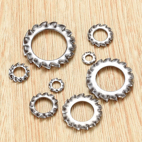 Stainless steel external-tooth star lock washers set, assorted sizes M2.5–M12, on wood background