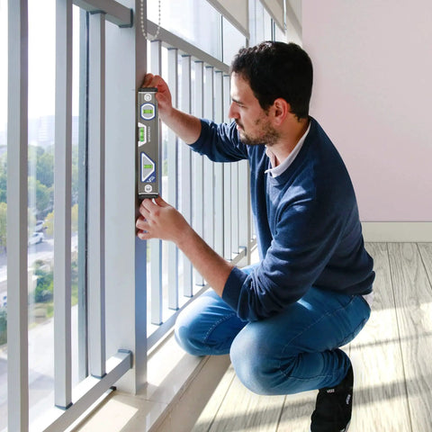 Person using Pro Grade 10 Inch Torpedo Level by WORKPRO with 3 bubble vials for horizontal vertical and 45 degree readings on window frame.