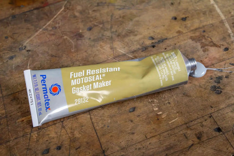Side view of MotoSeal 1 Ultimate Gasket Maker Grey tube on wood surface, 2.7 oz for frequent disassembly engines and two- and four-cycle motors.