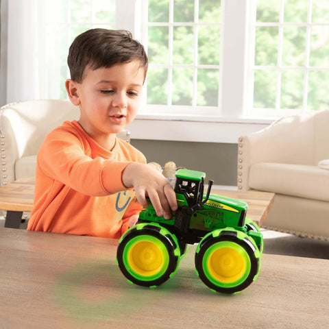 Child playing with John Deere Monster Treads Lightning Wheels Monster Truck Toy With Motion Activated Lights, Oversized Monster Truck Wheels