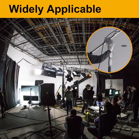 Film studio setup with crew, lighting equipment, and microphone held by a boom operator in a professional setting.
