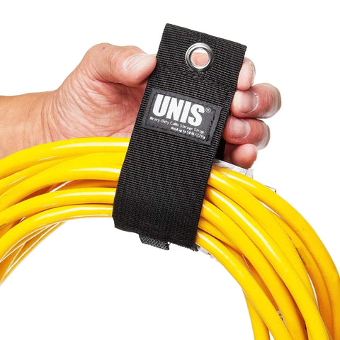 Hand holding yellow cables secured with black 8 Pack Heavy Duty Large 13 Inch Extension Cord Organizer Straps with hang loop.