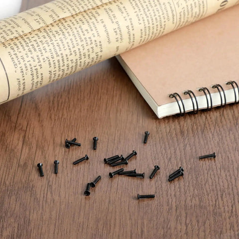 500 Pcs Extra Small Screws Micro Repair Kit in M1.2 M1.4 M2.0 Sizes with Black Finish, tiny screws scattered on table