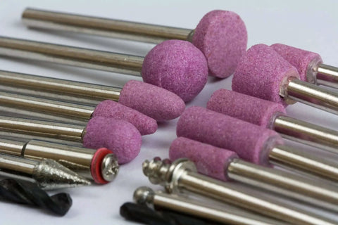 Close-up of accessory bits for All Purpose Rotary Tool Kit With Flex Shaft From WEN, 80 Piece Accessory Set, showing various grinding attachments.