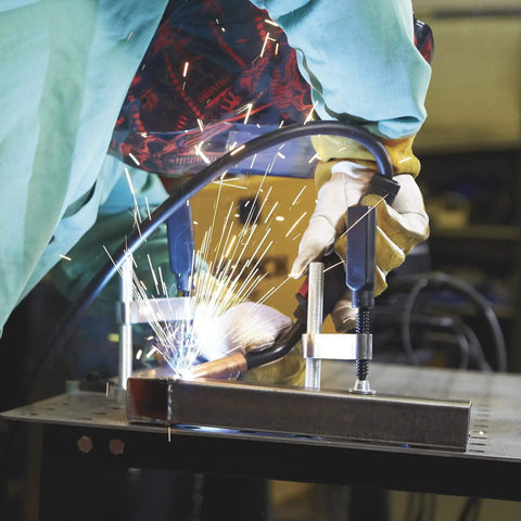 Welding in progress on mobile welding table with firm grip handle and heavy duty swivel casters for metal fit up kit