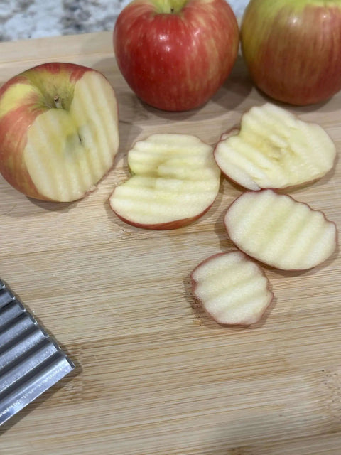 Crinkle Cut Wavy Blade Slicer For Fries And Veggies Stainless Steel French Fry Cutter creating wavy apple slices on a board