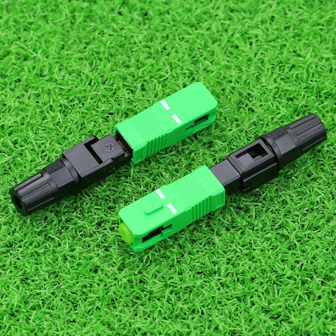 SC APC optical fiber quick connector pair, green and black housings with white alignment marks