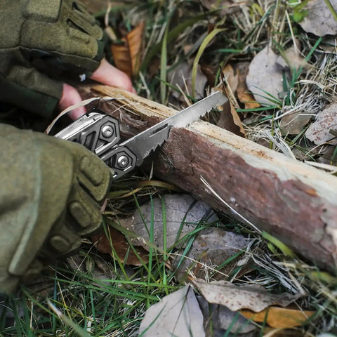 Multitool 21 In 1 Stainless Steel Pocket Knife With Screwdriver Sleeve Self Locking Pliers being used to saw a log outdoors.