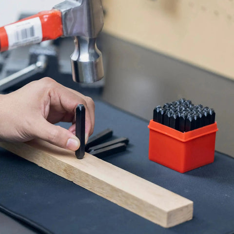 Hand holding a punch from a Number And Letter Punch Set With Heat Treated Steel Punches For Imprinting And Arts And Crafts For Hobbyists One Quarter Inch Shaft 36 Piece Stamp Kit For Beginners