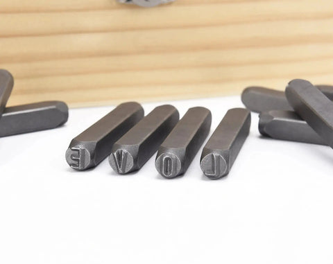 Close-up of metal punches from 36 Piece Letter And Number Stamp Set With 6mm Height In A Wooden Case Beefy 40Cr Alloy Steel