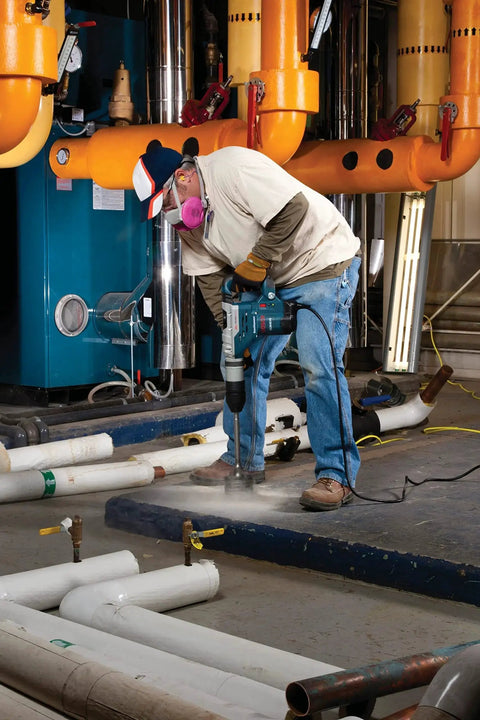 Worker using Beefed Up Heavy Duty SDS Max Rotary Hammer Core Bit For Concrete By Bosch, 2 Five Eighths In X 22 In on pipes