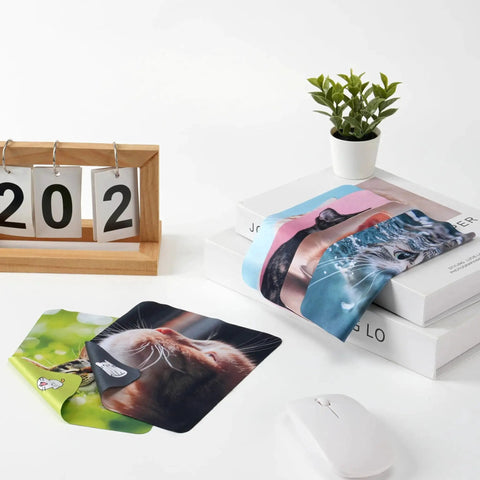 Cute Cat Microfiber Cleaning Cloths 6 Pack For Glasses Phones Screens Cameras displayed on a desk with books and a plant.