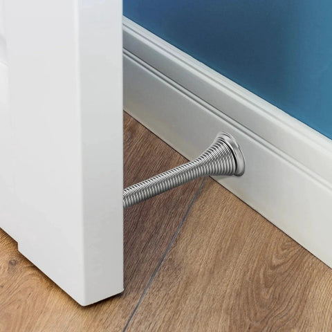 Spring Door Stops With Rubber Bumpers Satin Nickel 12 Pack For Bottom Of Door installed in a room with wooden flooring.