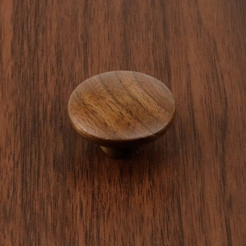Round walnut wood cabinet knob on surface, part of 10 Pack Round Walnut Wood Cabinet Knobs With Screws 1.57 Inch Diameter Ideal For Cabinets Dresser