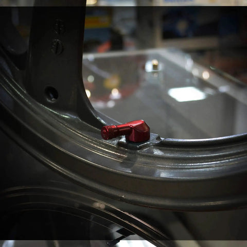 Forged Alloy Angled Valve Stem With Pre Applied Threadlocker Nut 0.357in Size Red installed on a standard rim opening