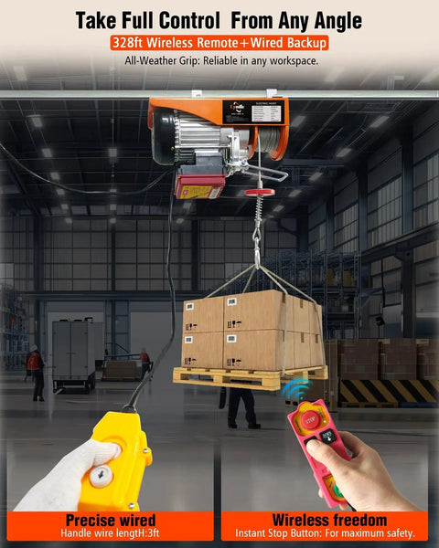 Orange electric hoist lifts a pallet of boxes in a warehouse; yellow wired remote and red wireless remote in foreground.