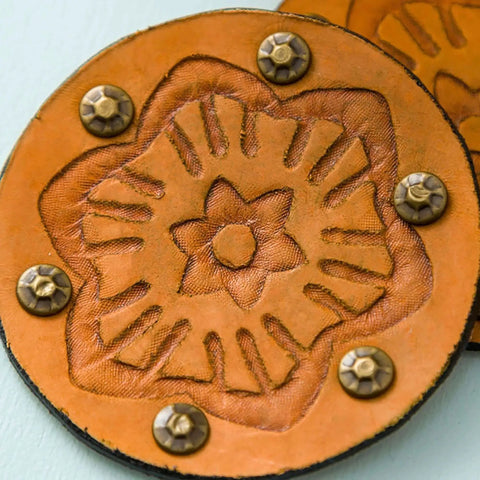 Close-up of a debossed leather craft design with floral pattern and rivets, created using Fine Debossing Tip With QuickSwap Housing.