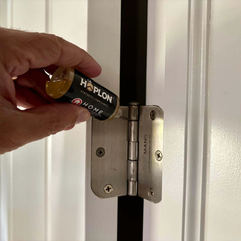 Applying All-In-One 5oz Synthetic Ester Lubricant Spray With Precision Needle on a door hinge.