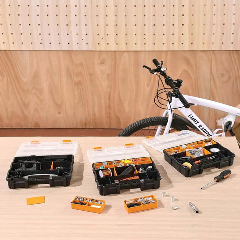 3-Pack Small Parts Organizer Case Set With 21 Compartments, Removable Dividers on a workbench near a bicycle