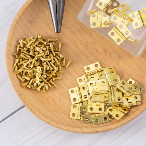 Thirty Pieces Small Brass Hinges For Crafts With 120 Screws And Nails, 13 X 12 Mm on wooden plate for DIY projects.