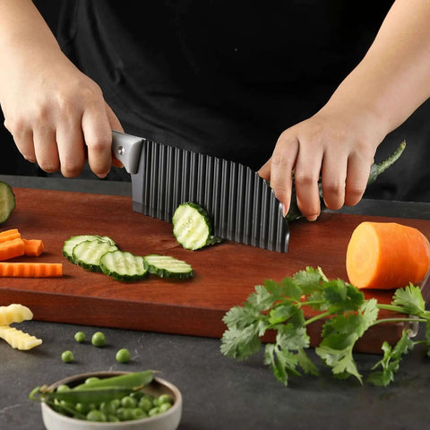 Crinkle Cut Knife For Veggies And Fries With Stainless Steel Wave Blade And Soft Rubber Handle cutting cucumber slices on a wooden board