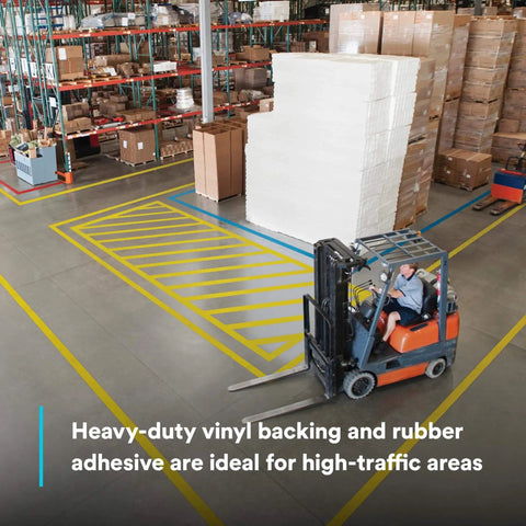 Warehouse floor with Durable Floor Marking Tape 971 Single Roll Yellow 4 in x 36 yd, used for designating forklift areas.
