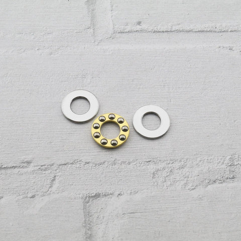 3-piece thrust ball bearing set: chrome steel washers plus a gold-toned inner bearing ring with balls.