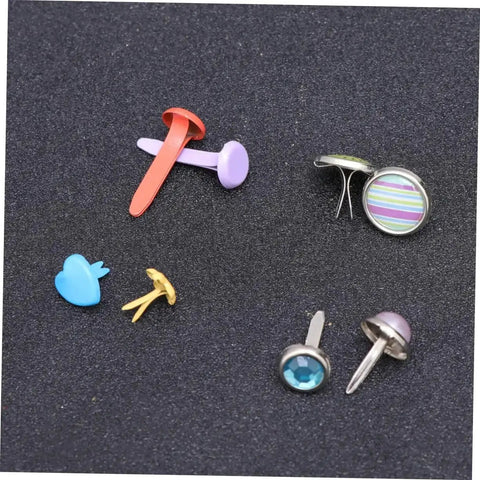 Colorful Metal Brads Fasteners Set For DIY Crafts Scrapbooking And Cardmaking Easy To Use Embellishment Kit With Storage Box Vibrant Colorful Staples For Creative Projects And Paper Craft Decor assorted brads on dark surface