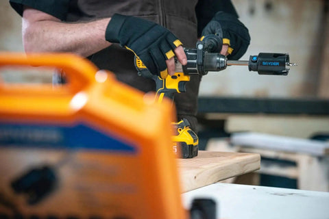 Person using Six And A Quarter Inch Carbide Tipped Hole Saw With Beast Mode Performance Delivers Up To 10x More Cuts And 5x Faster Drilling Through Fiber Cement Board Wood PVC Plastic Concrete Block Ceramic Tile And More With Spyder Rapid Core Eject Arbor System on wooden surface.
