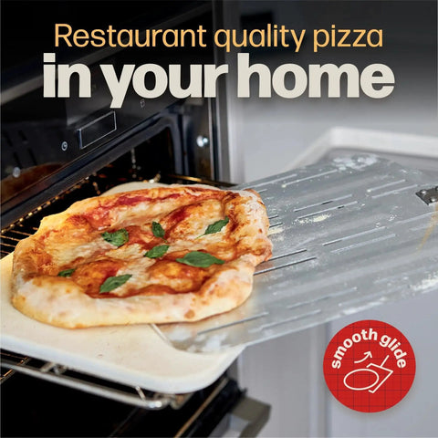 Pizza Peel Pro For XL Pizzas Perforated Nonstick Paddle retrieving a pizza from an oven, showing perforated metal surface and wooden handle.