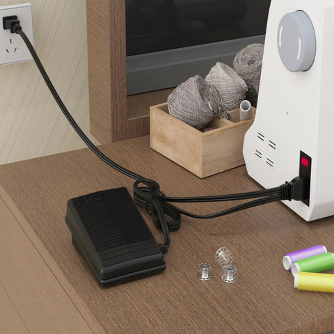 Sewing machine foot pedal with power cord (black) plugged into a white sewing machine on a wooden desk