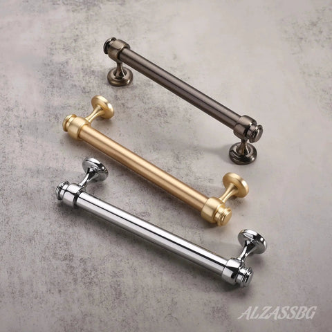 Three straight bar cabinet handles in polished chrome, brushed gold, and matte black finishes displayed on a marble surface.