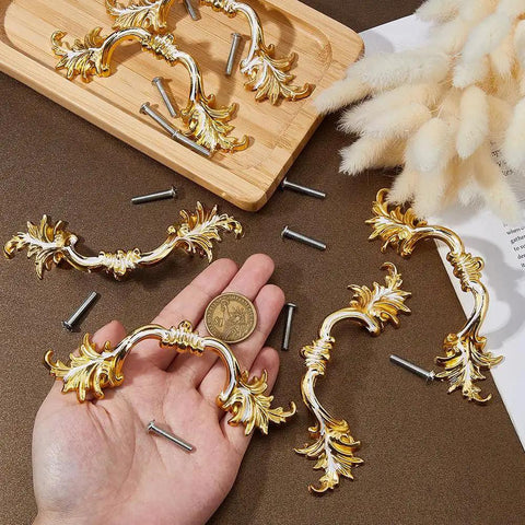 Hand holding one of the Six Piece European Style Vintage Cabinet Handles Pulls 5 Inch Alloy Antique Golden Drawer Knobs, screws nearby.