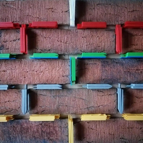 Pro Grade Leveling And Spacing Shims Kit With 150 Pcs U Shaped Tile Spacers 1mm 2mm 3mm 4mm 5mm 6mm For Window And Door Installation And Woodworking By Left Bridge displayed on a brick wall.