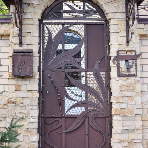 Decorative metal gate with intricate design set in a stone wall, suitable for Six Pack 4 Inch Bullet Weld On Hinges Set Heavy Duty Weldable Barrel Hinges Carbon Steel for Detachable Metal Swing Doors Gates Driveways Trailers and Ramps Ensures Secure Lids Easy Flipping and Durable Grilling.