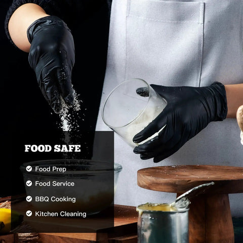 Person wearing Heavy Duty Black Nitrile Exam Gloves 6-Mil Large 100 Count Latex Free Food Safe, handling food in kitchen.