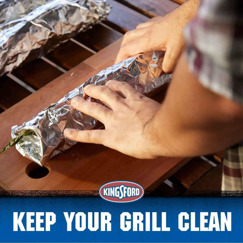 Hands wrapping food in Extra Wide Aluminum Foil Roll For Grilling And Baking Heavy Duty 18 Inch By 100 Sq Ft on a wooden surface.