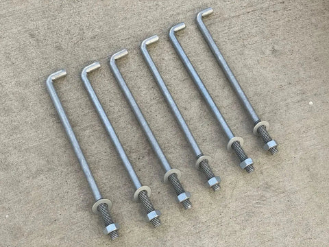 Half Inch By Ten Inch Threaded Concrete Anchor L Bolts With Nuts And Washers Included Hot Dipped Galvanized displayed on concrete.