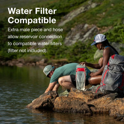 Two hikers using a Hydraulics Quick Connection Kit For Water Reservoir System Quarter Inch Hose Fittings With Easy Disconnect Includes Extra Male Piece And Hose For Water Filters Compatible With Osprey Hydraulics Reservoirs near a stream.