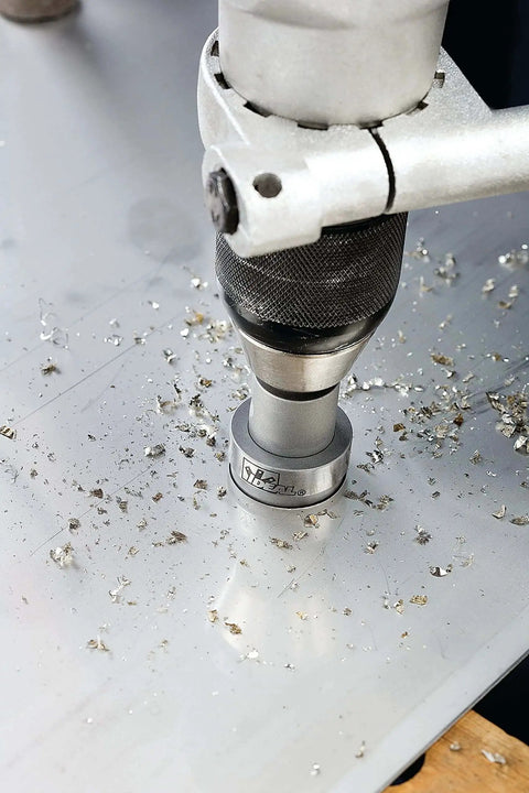 TKO Carbide Tipped Hole Cutter Kit drilling clean hole in metal sheet with Smooth Start Pilot Bit, side view