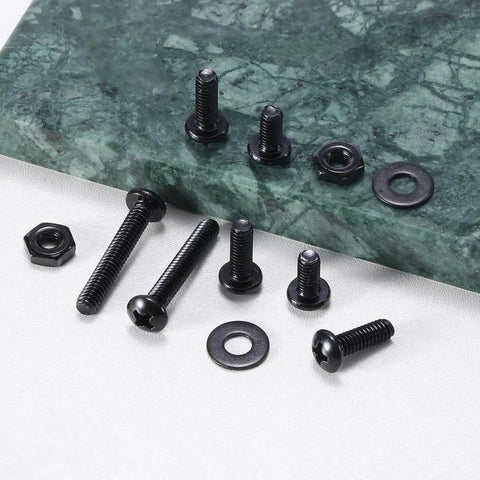 Black machine screws, nuts, and washers on a green marble surface, part of 381 Piece Machine Screws Nuts And Bolts Kit With Case DIY Ready For Quick Repairs And Projects Includes 6-32 8-32 10-24 Phillips Pan Head Stainless Steel Bolts Nuts And Flat Washers In Black Oxide 304 Stainless Steel Variety Pack.