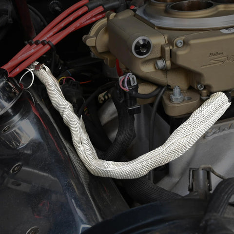 Split sleeve RFI shielding in silver braided metal around automotive hose near intake manifold